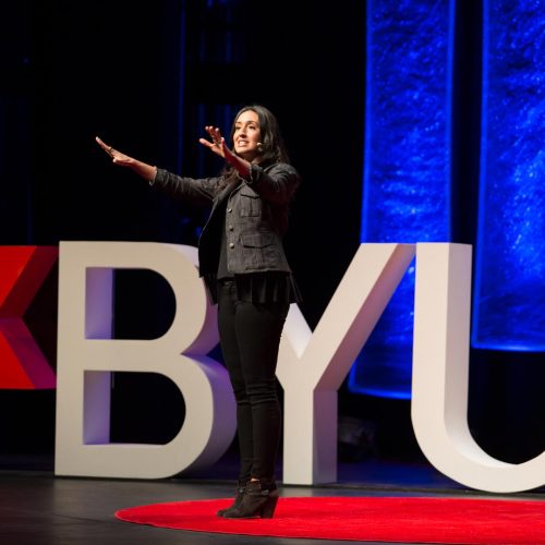 Erica gesturing to the crowd on the TEDxBYU stage