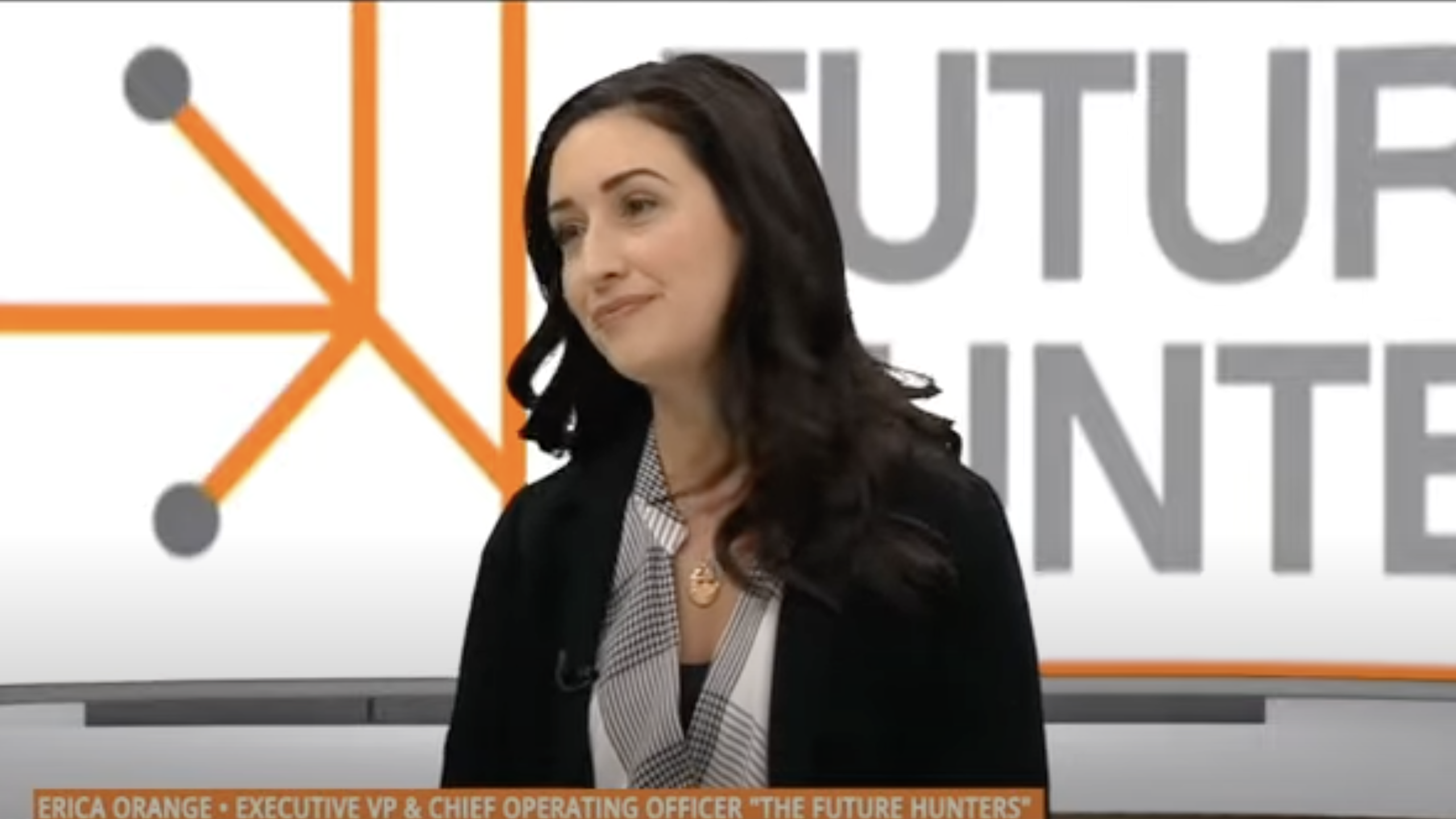 Erica Orange sitting in front of a screen with The Future Hunters logo on the ADN 40 News show in Mexico